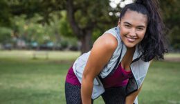 young smiling woman resting after an active fitness training outdoors during COVID-19