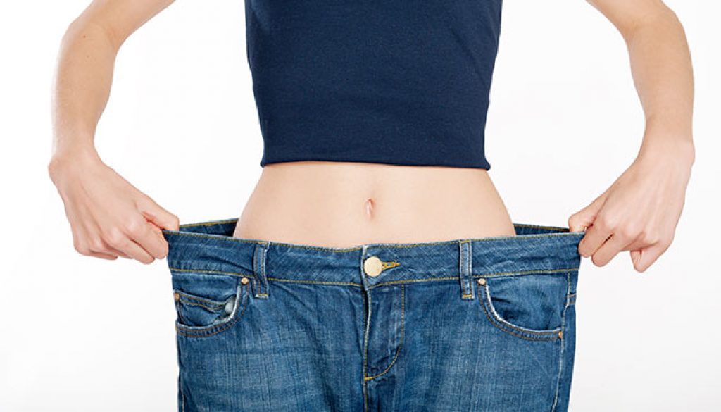 successful weight loss, woman with too large jeans after choosing the right type of bariatric surgery