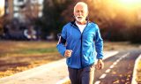 Elderly man running on a track with earbuds in hip replacement surgery