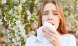 Woman sneezing into a tissue seasonal allergies