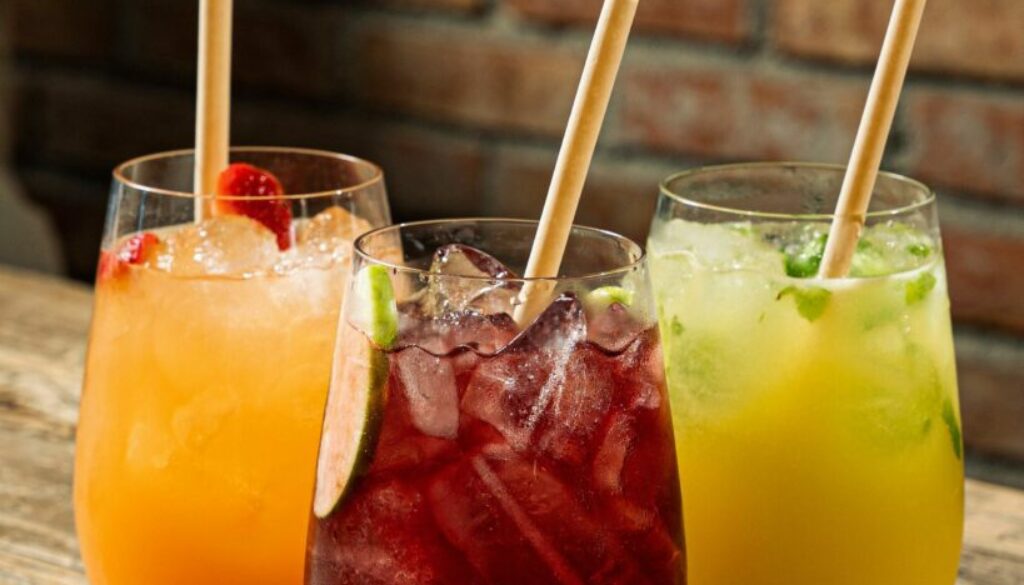 Vertical shot of three colorful mocktail drinks with straws