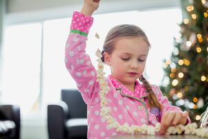 Girl making popcorn garland at home