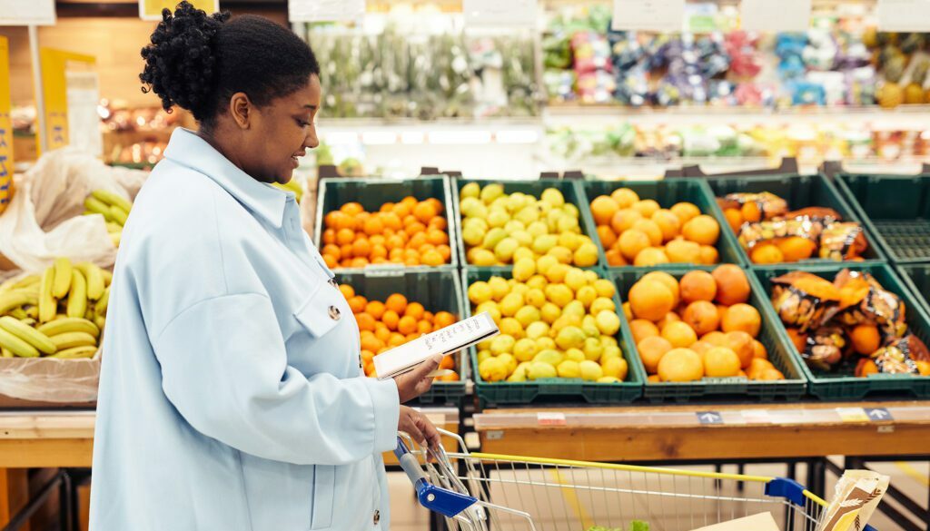 African american woman checking her grocery list while in the store healthy grocery shopping