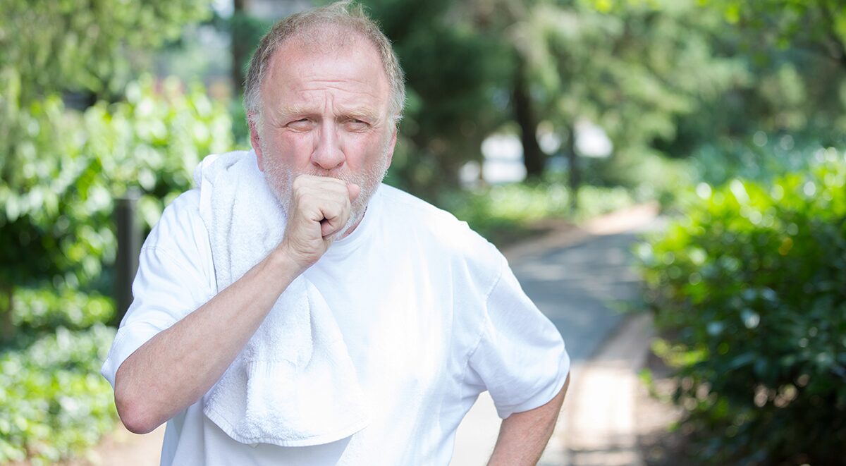 Elderly man coughing outdoors dealing with COPD Flare-ups