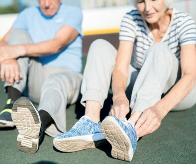 A Senior Couple Sitting on an Outdoor Running Track as the Woman Ties Her Shoes Occupational Therapy