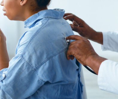 Black male doctor checking breath of female patient